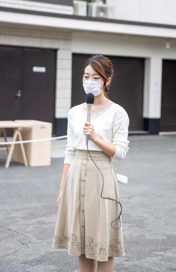 A girl in a mask with a microphone in her hand.