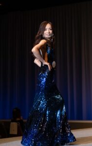 A candidate wearing a silky, sparkling blue gown