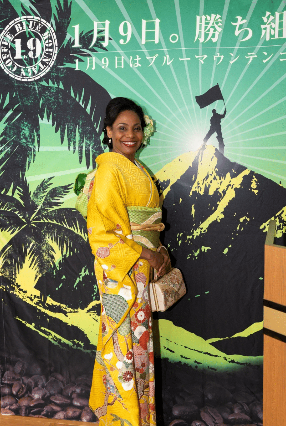 Ambassador Shorna-Kay Richards wearing a vibrant yellow furisode kimono with Jamaican flag colors for Jamaica Blue Mountain Coffee Day.