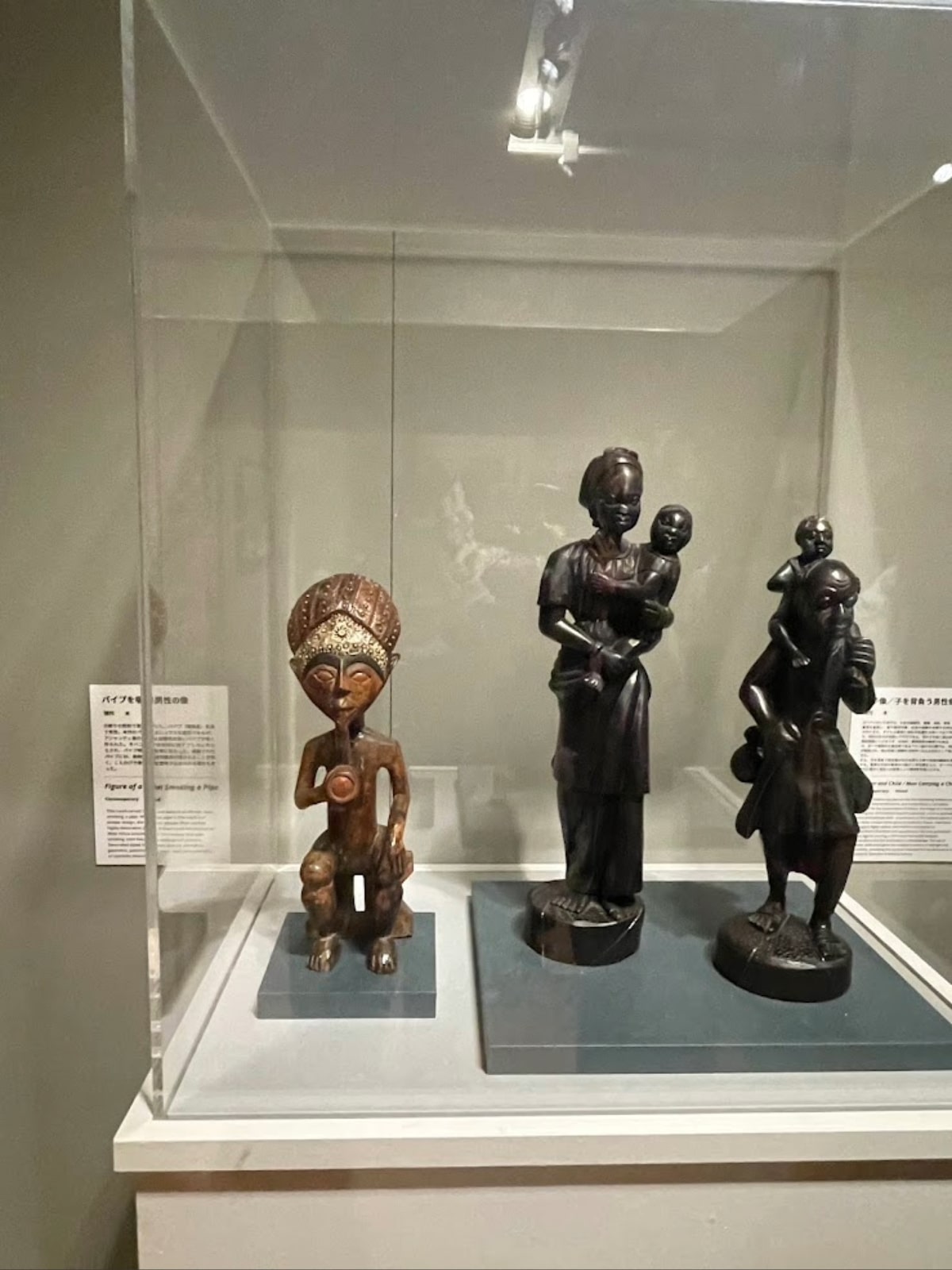 Traditional Ghanaian carved wooden masks and statues on display at the Tokyo Fuji Art Museum.