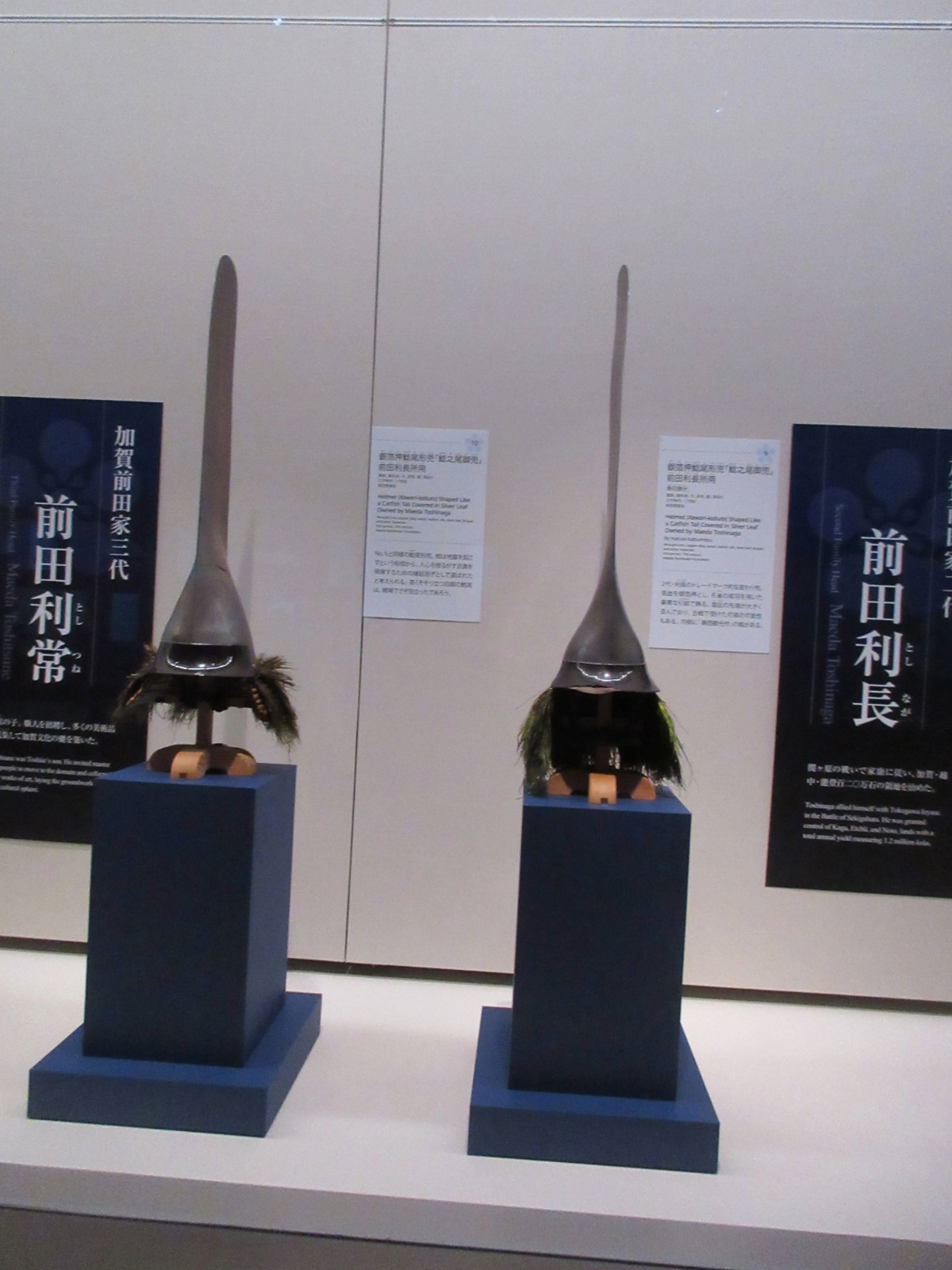 Two traditional Japanese samurai helmets with distinctively long silver catfish tail designs.