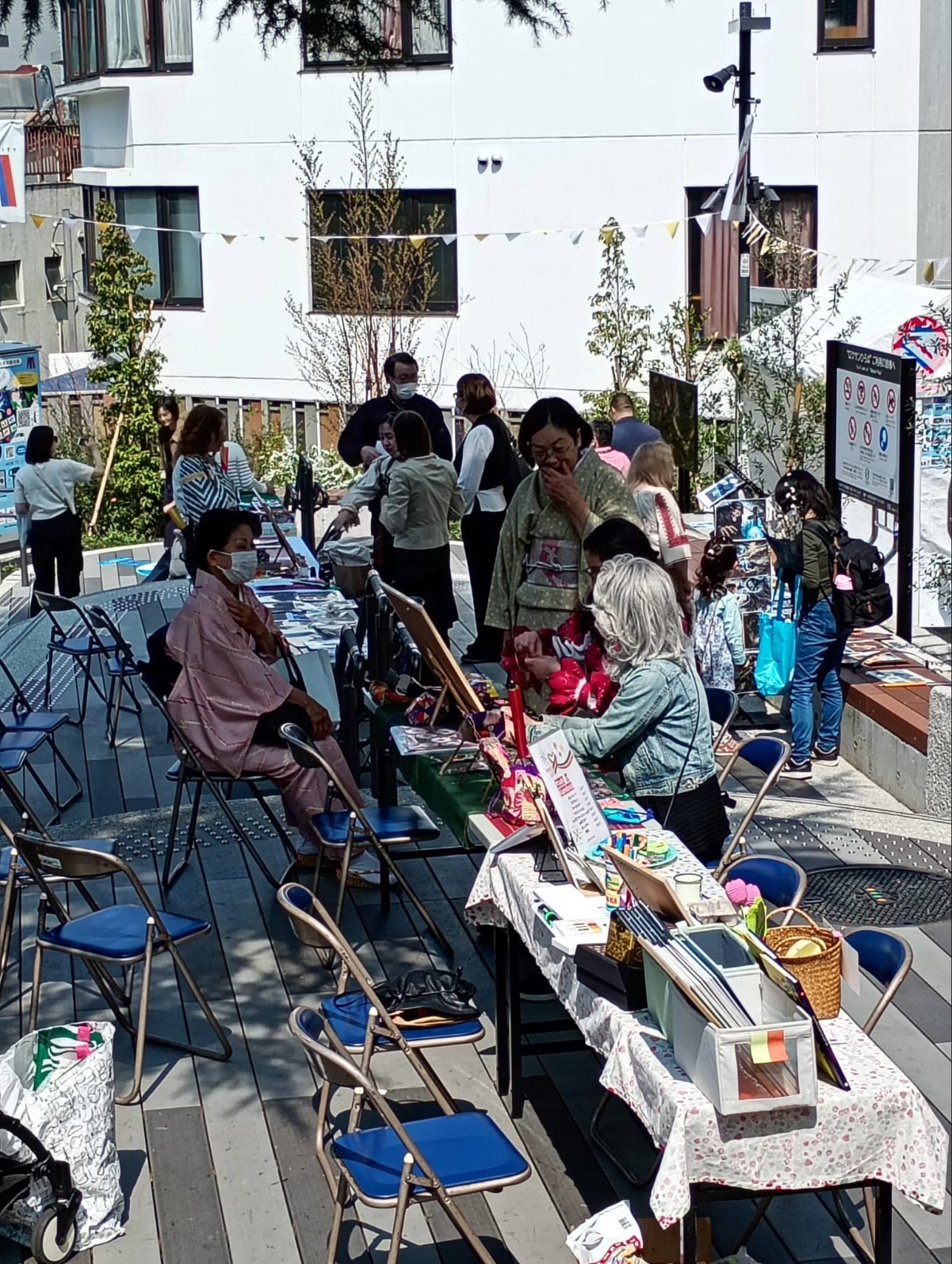 Participants engaging in the Mărțișor making workshop led by Sezătoare JaponIA at the outdoor festival.