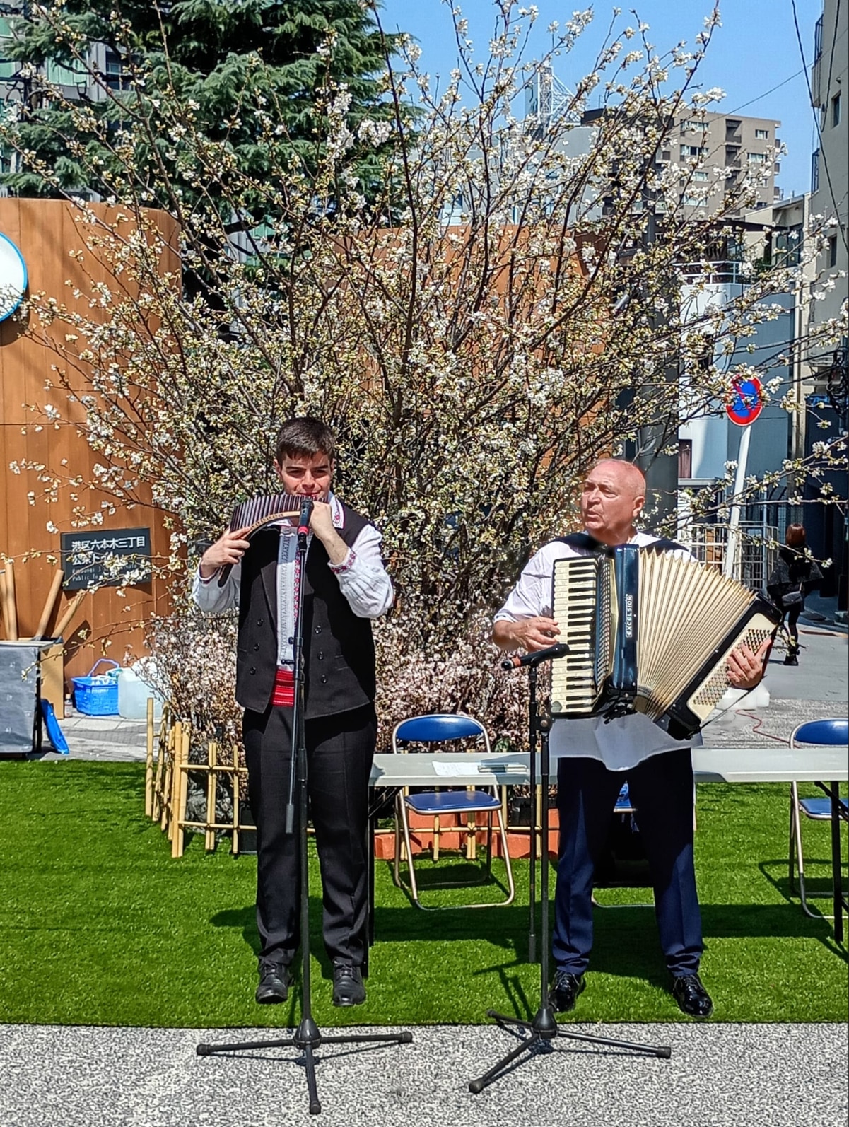 Musicians performing traditional Romanian music with a pan flute and accordion during the spring festival in Tokyo.