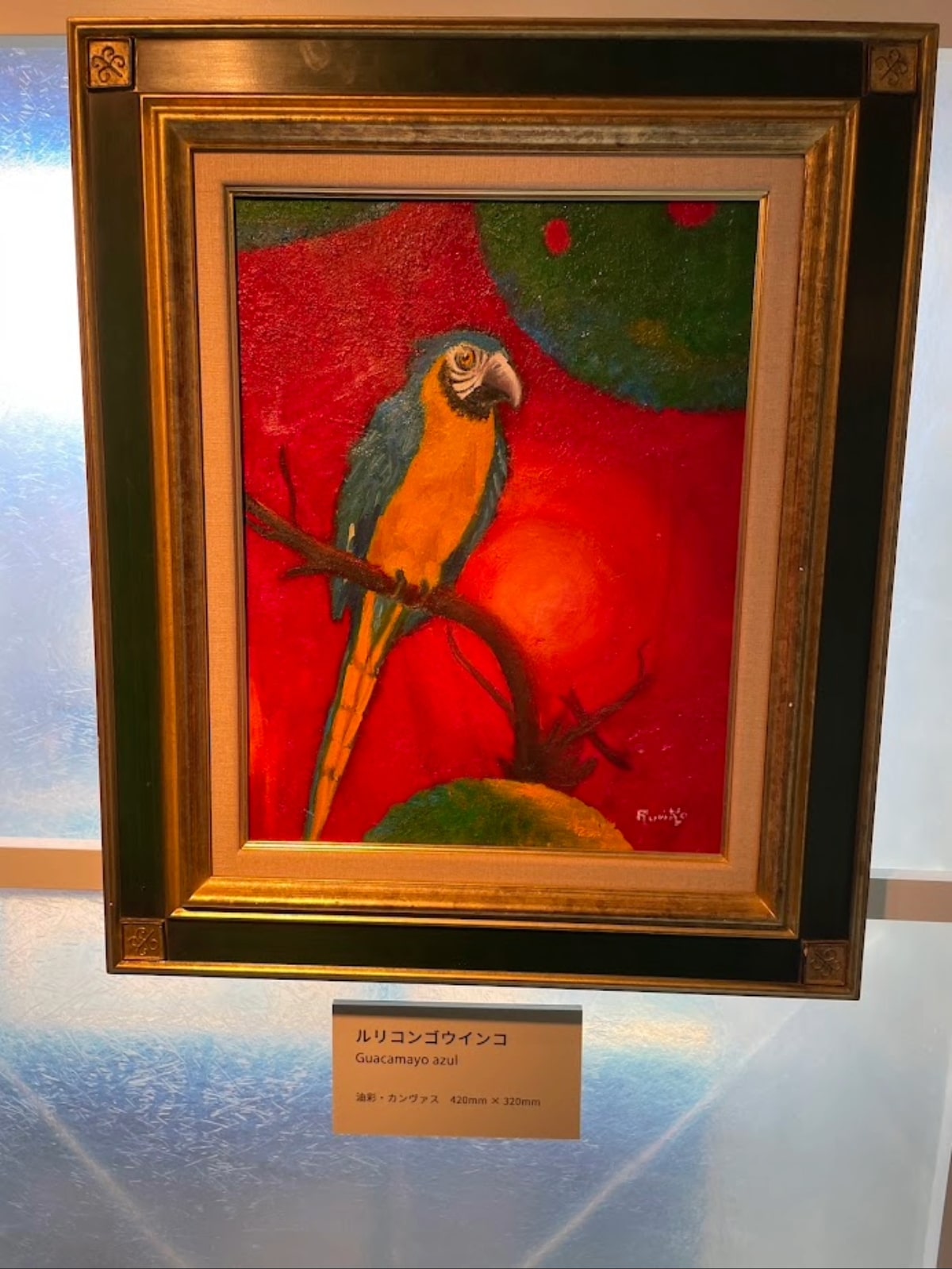 A bright oil painting of a blue and yellow macaw (Guacamayo azul) by Ruriko Escobar, depicting Salvadoran wildlife.