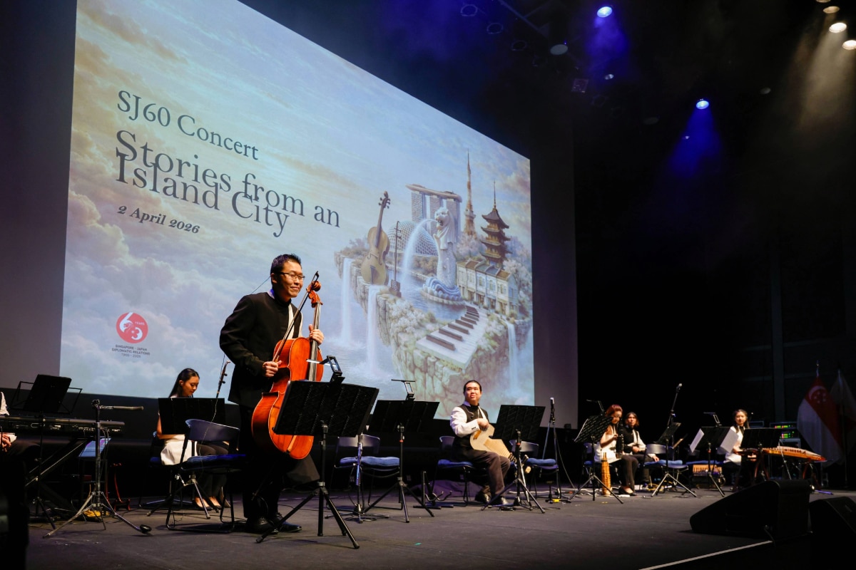 The TENG Ensemble performing at the SJ60 concert "Stories from an Island City" in Tokyo, featuring a large digital backdrop of Singapore and Japan landmarks.