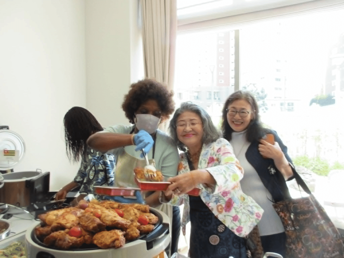AWAAJアフリカバザーで日本人来場者にアフリカ料理を振る舞うスタッフ