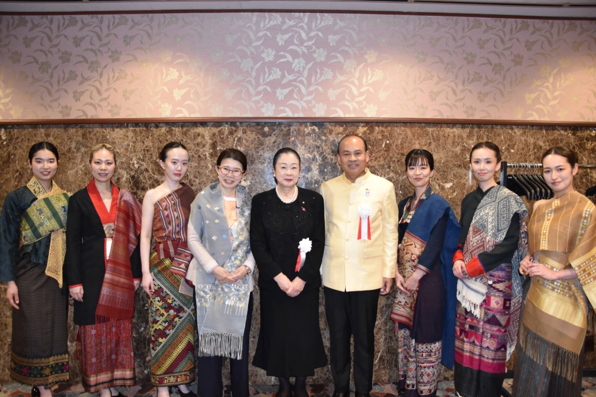 LAO FASHION AND CULTURE FESTIVALにて、アンパイ・キンダヴォン大使と日本人来賓が、ラオス伝統の織物を身にまとったモデルたちと記念撮影