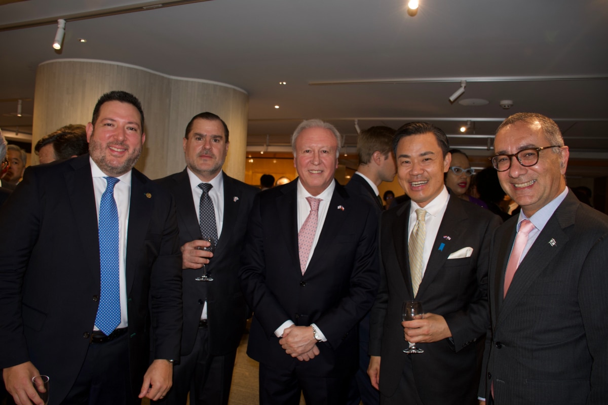 Ambassador Ricardo Rojas and guests pose in front of the Chilean flag at his farewell event in Japan
