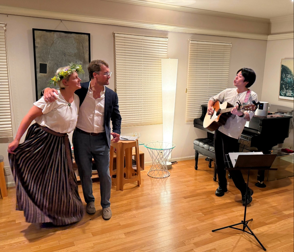 Ambassador Zigmārs Zilgalvis and his wife Ilona Zilgalve are serenaded with a farewell song by a guitarist at the Latvian Embassy reception.