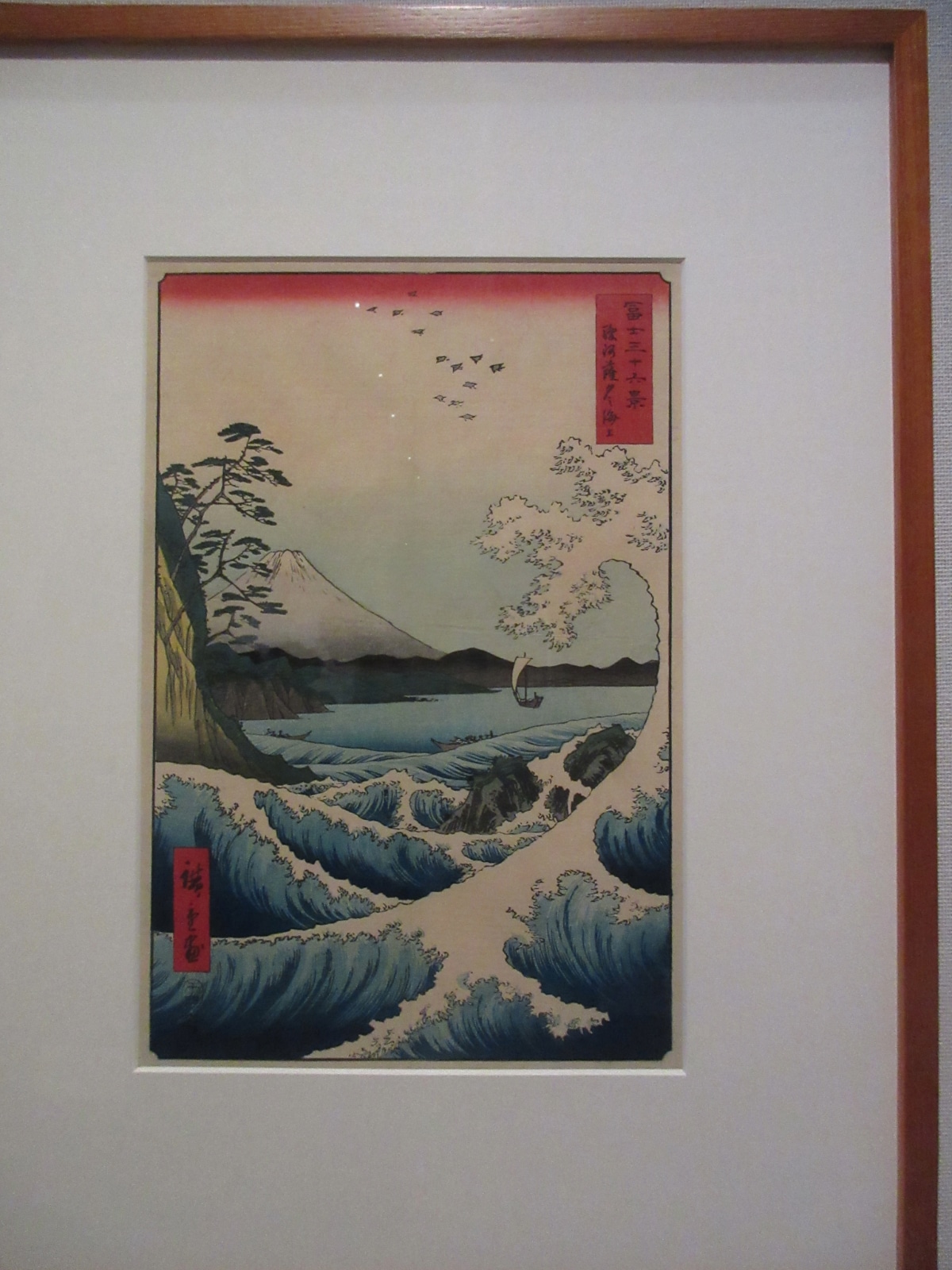 "Hiroshige's Suruga coast print showing a curling wave, sailboat, and Mount Fuji"