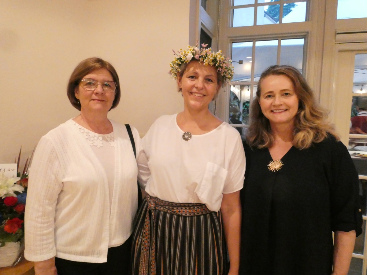 Guests in traditional Latvian folk costume and a floral crown pose together at the Latvian Embassy farewell reception in Tokyo.