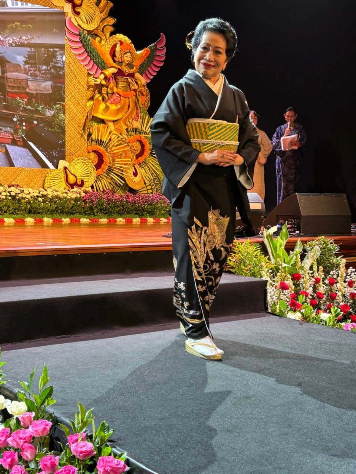 Woman in elegant black kimono walking runway at Bali Arts Festival 2026 fashion show