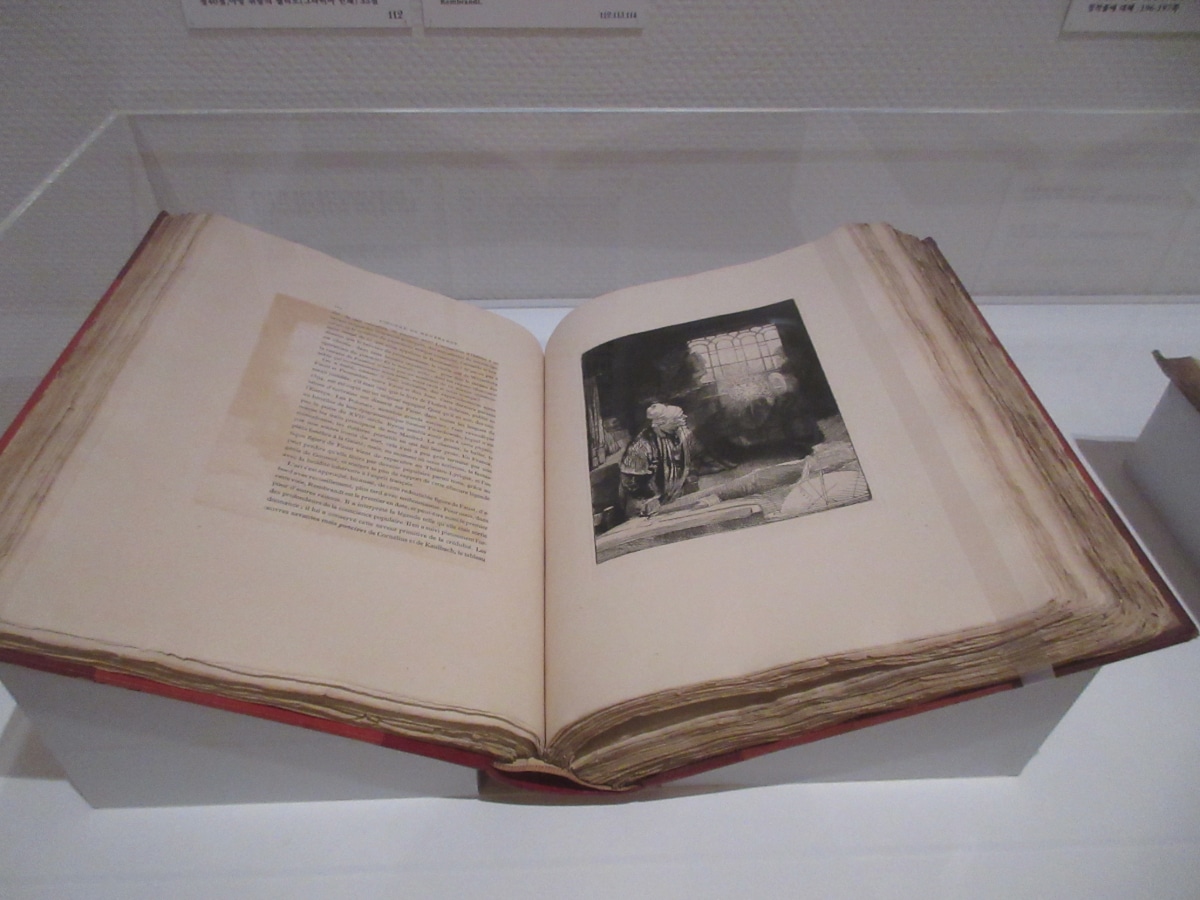 Antique book displaying a reproduced Rembrandt etching