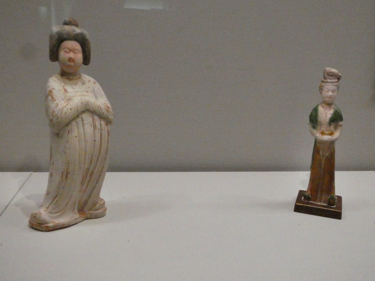 Two ancient Chinese-style ceramic figurines of women, one white-glazed and one three-color glazed