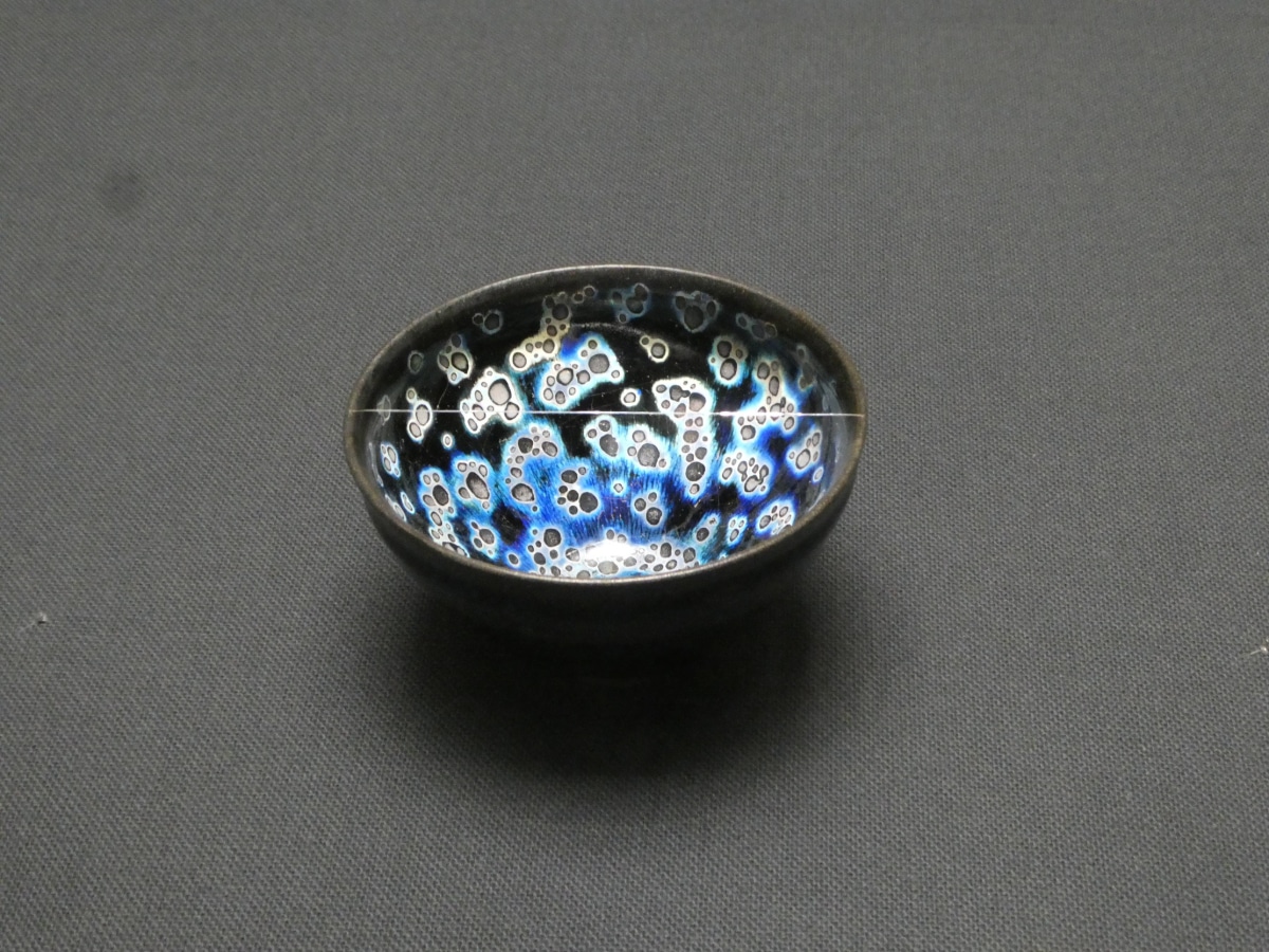 Yohen tenmoku tea bowl with blue and silver spots on black glaze, shown at the Kawai Kanjiro exhibition