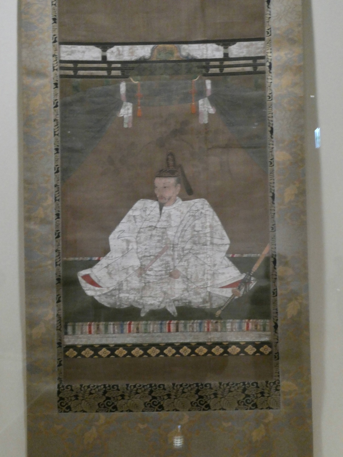 Portrait of Toyotomi Hideyoshi in a white robe seated on a striped-border tatami mat at the Edo-Tokyo Museum