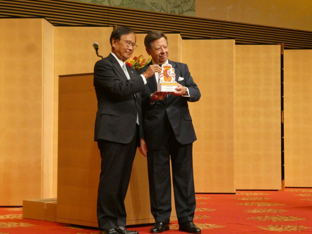 Presentation of a Spanish coat-of-arms plaque on stage at the Spain National Day reception, symbolizing Japan-Spain friendship