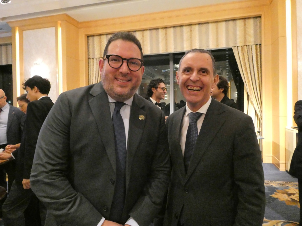 Two men in dark suits smile together at the Armenia Independence Day reception