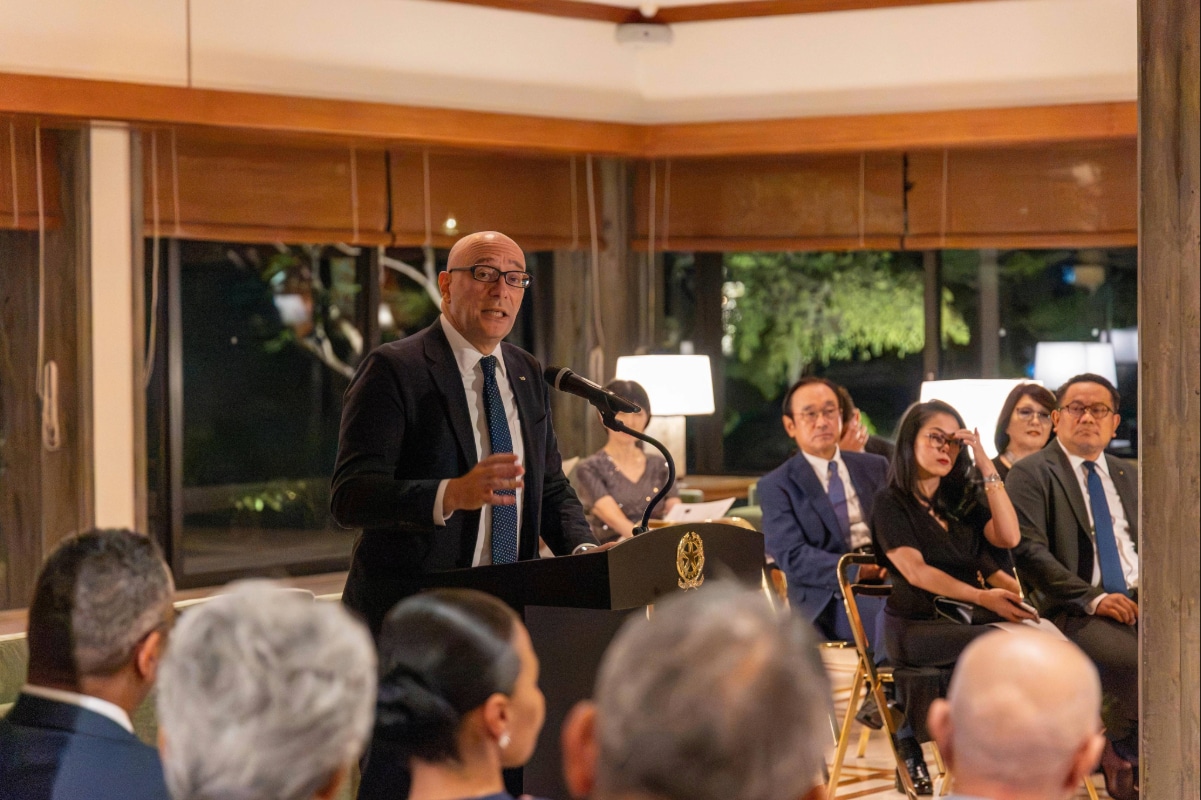 Speaker delivering remarks at a podium to guests at the piano recital held at the Italian Ambassador’s residence