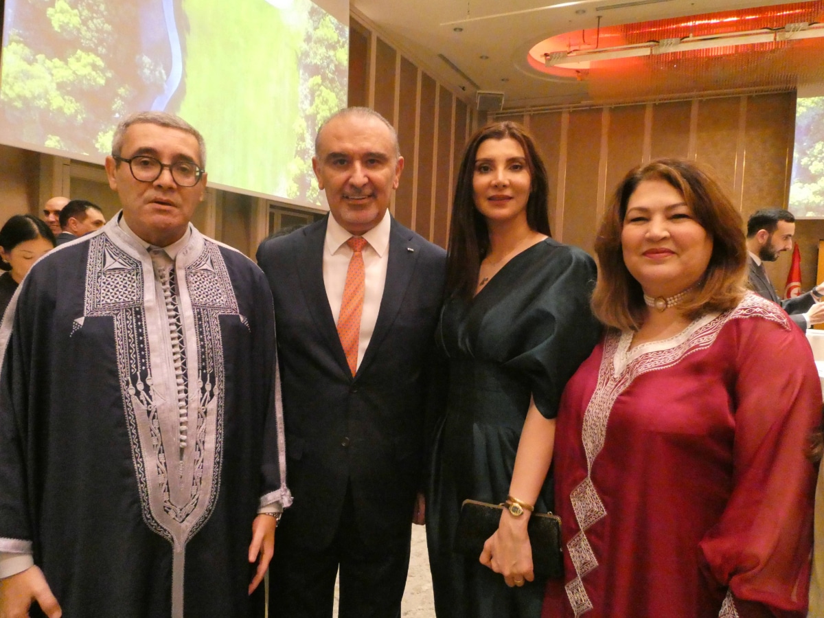 Four people in formal and traditional dress posing together at the Tunisia-Japan anniversary reception