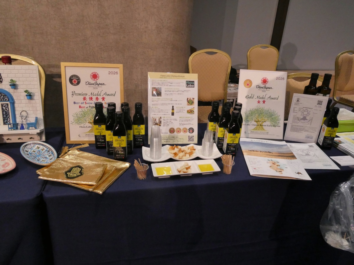 Tunisian olive oil bottles displayed with Olive Japan 2026 medal award certificates and a tasting plate